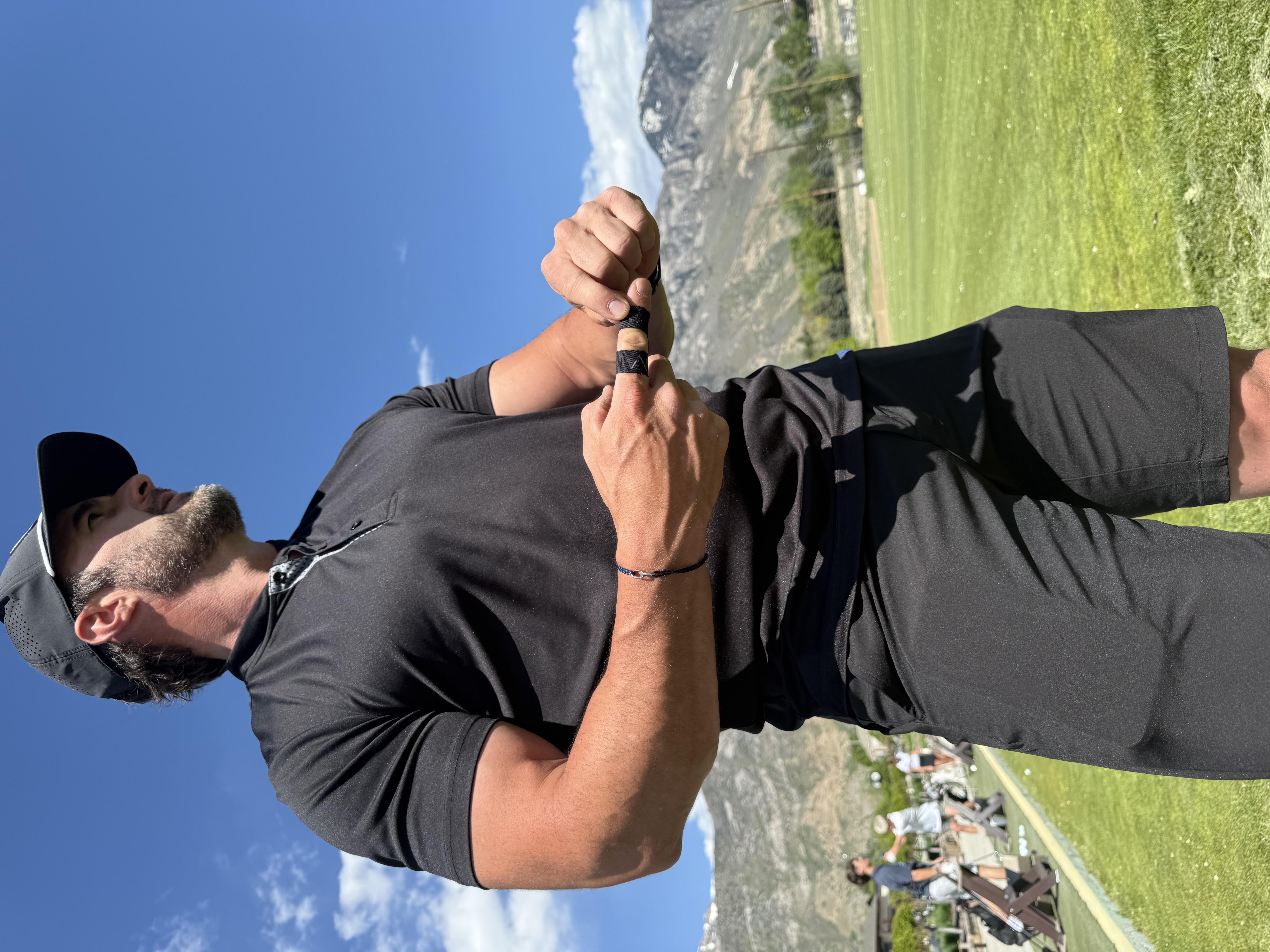 Matson Tanner applying Atlas finger tape at the driving range